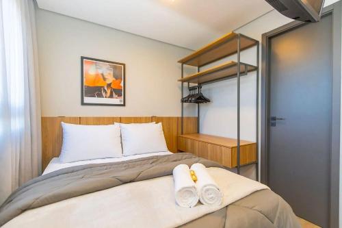 a bedroom with a bed with two towels on it at Vibe Curitiba by Housi, próximo à Ligga Arena e Praça do Japão in Curitiba