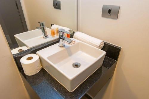 a bathroom with a white sink and a mirror at Vibe Curitiba by Housi, próximo à Ligga Arena e Praça do Japão in Curitiba