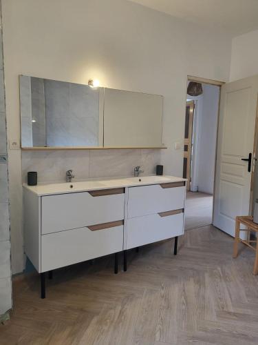 une salle de bain avec un lavabo blanc et un miroir dans l'établissement Au petit bonheur - 2, à Marignac