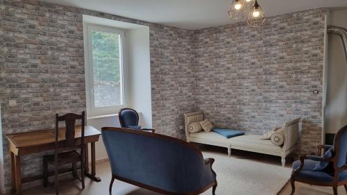 un salon avec un canapé et un mur de briques dans l'établissement Au petit bonheur - 2, à Marignac