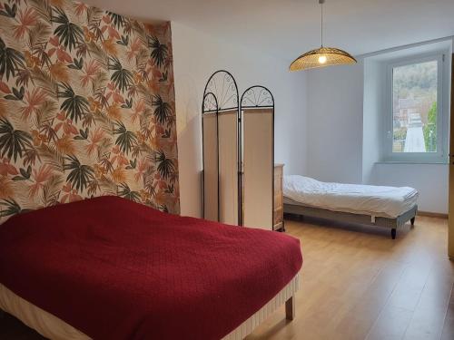 - une chambre avec 2 lits et un couvre-lit rouge dans l'établissement Au petit bonheur - 2, à Marignac
