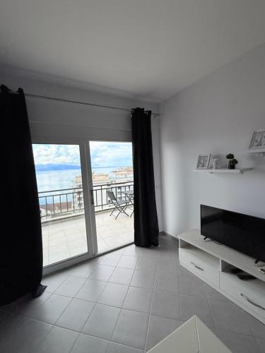 a living room with a large sliding glass door at Azalea Apartments in Sarandë