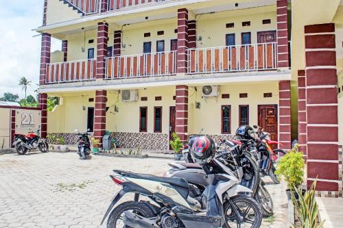 a group of motorcycles parked in front of a building at Hotel O Kos 21 in Kupang
