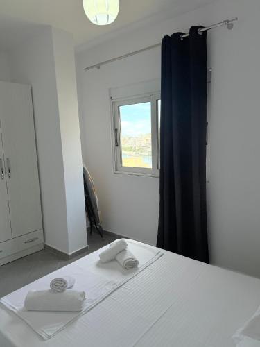 a bedroom with a bed with two towels on it at Azalea Apartments in Sarandë