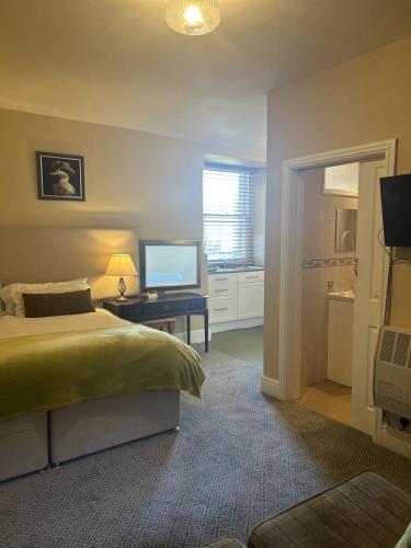 a bedroom with a bed and a television on a table at Moresby Hall Country House Hotel in Whitehaven