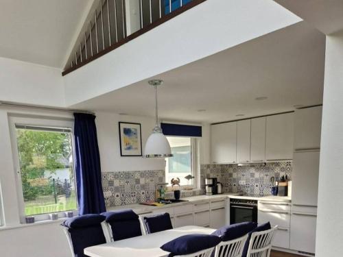 a kitchen with a white table and chairs and a table and a window at Ferienhaus am See 19 in Zehdenick
