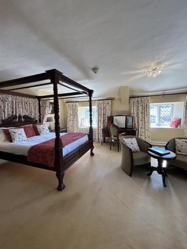 a bedroom with a canopy bed and a living room at Moresby Hall Country House Hotel in Whitehaven