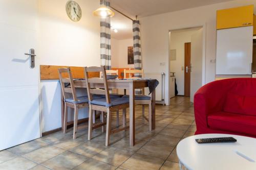 a living room with a dining room table and a red couch at Ferienwohnung Mit Balkon Und Geschirrspülmaschine in Weißenstadt