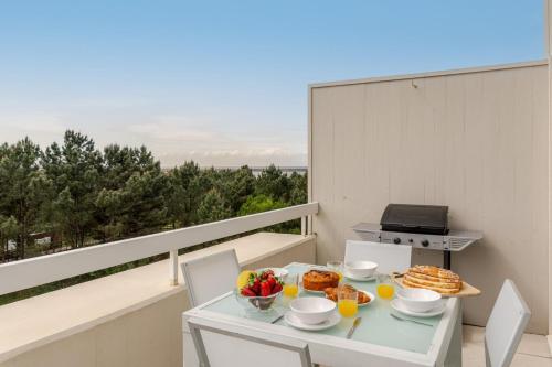 een tafel met eten en fruit op een balkon bij Ocean Bliss - Beach & BBQ Apartment in Viana do Castelo