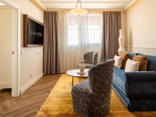 a living room with a couch and chairs and a table at Only YOU Hotel Sevilla in Seville