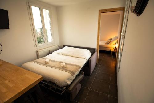Un dormitorio pequeño con una cama y una ventana. en Le Panorama Valentinois, en Valence