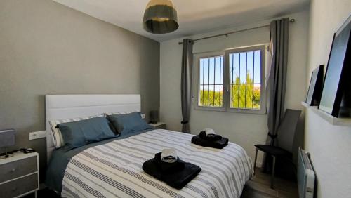 ein Schlafzimmer mit einem Bett mit zwei schwarzen Handtüchern darauf in der Unterkunft Naranjos House in Muntanya la Sella