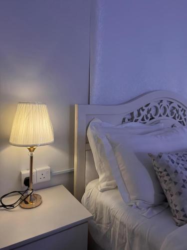 a bedroom with a bed with a lamp on a night stand at مسكن كازان in Abha