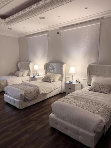 a room with two beds and two tables with lamps at مسكن كازان in Abha