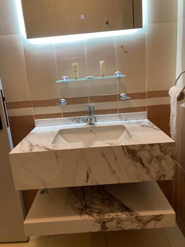 a bathroom with a marble sink and a mirror at Uptown Hotel Apartment in Amman