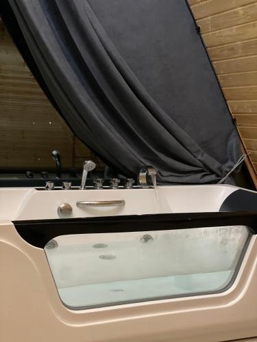 a white bath tub with a curtain in a room at eco house WALKOTI 2 in Chanadirtkari