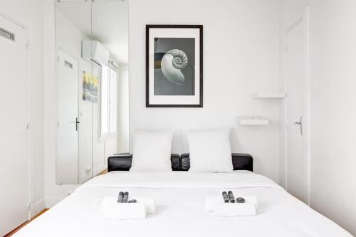 - une chambre avec un lit blanc et 2 oreillers blancs dans l'établissement Duplex cozy a Proximite de la Tour Eiffel with AC, à Paris