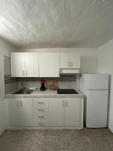 a kitchen with white cabinets and a white refrigerator at Casa ADOLFO in Almáciga