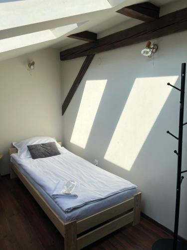 a bedroom with a bed in a room with beams at Pokoje przy Dworcu in Przemyśl