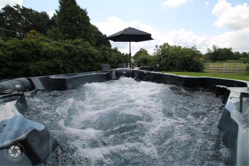a plunge pool filled with water with an umbrella at Home with HotTub near AltonTowers & Waterworld sot in Stoke on Trent