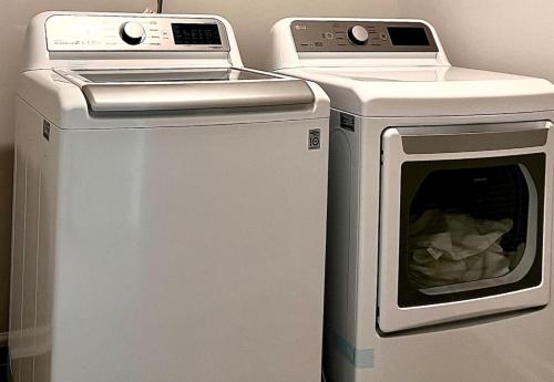 a dryer and a washing machine next to each other at The Villas The One Villa by RDU Airport with Indoor Heated Pool and Gym in Durham