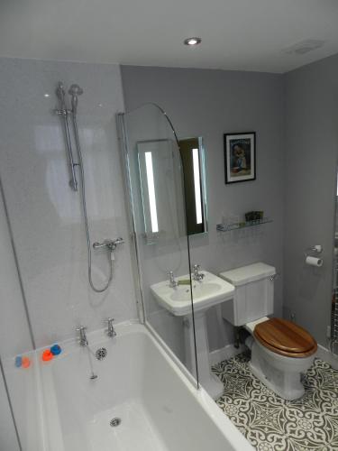 a bathroom with a tub and a toilet and a sink at White Swan Inn in Belford