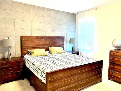 a bedroom with a large wooden bed with yellow pillows at The Villas The One Villa by RDU Airport with Indoor Heated Pool and Gym in Durham
