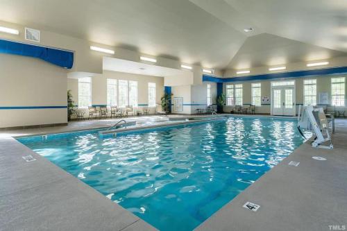 a large swimming pool with blue water at The Villas The One Villa by RDU Airport with Indoor Heated Pool and Gym in Durham