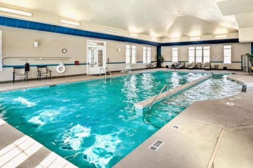 a swimming pool with blue water in a building at The Villas The One Villa by RDU Airport with Indoor Heated Pool and Gym in Durham