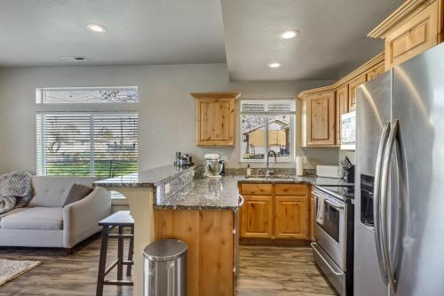 a kitchen with wooden cabinets and a stainless steel refrigerator at Hill Field Stays by Cloud Dream Homes in Layton
