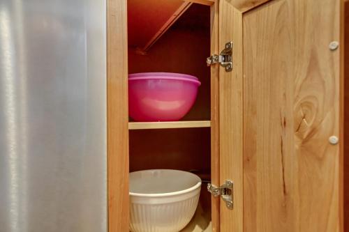 a cupboard with a pink bowl and a bucket at Hill Field Stays by Cloud Dream Homes in Layton