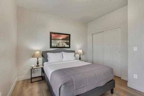 a white bedroom with a bed and two lamps at Hill Field Stays by Cloud Dream Homes in Layton