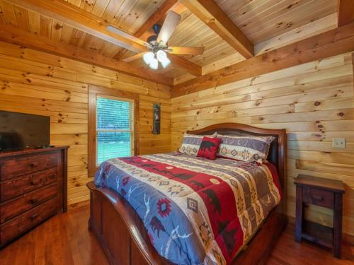 a bedroom with a bed and a ceiling fan at Timber Cabin with Hot Tub and Outdoor Space in Maggie Valley