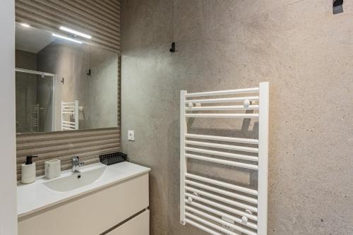 une salle de bain avec un lavabo et un miroir dans l'établissement KARUKERA Bel appartement avec jardin au cœur de Chiberta, à Anglet