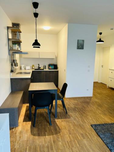 eine Küche und ein Esszimmer mit Tisch und Stühlen in der Unterkunft Modernes Business-Apartment, 2 Zimmer, zentrale Lage in Hamburg in Hamburg