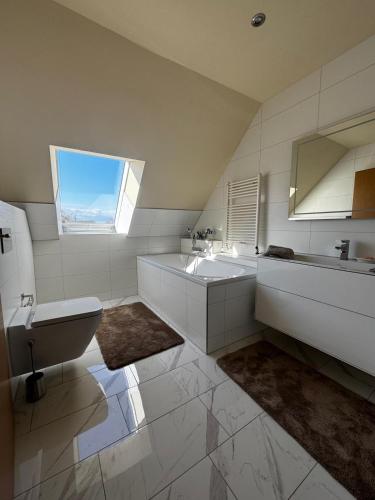 a bathroom with a sink and a toilet and a window at Kranichstube in Rövershagen