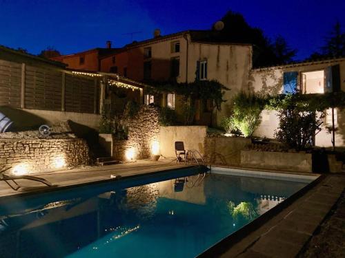 - une piscine éclairée à côté d'une maison dans l'établissement L'ancienne Forge, à Villarzel-du-Razès