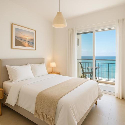 a bedroom with a bed and a view of the ocean at Sweet apartment in Netanya