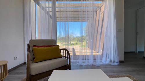 a living room with a chair and a large window at LAZY HIKERS by Nature Bliss in São Luis