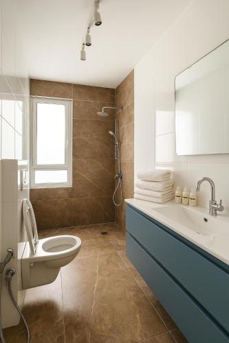 a bathroom with a sink and a toilet and a tub at Sweet apartment in Netanya