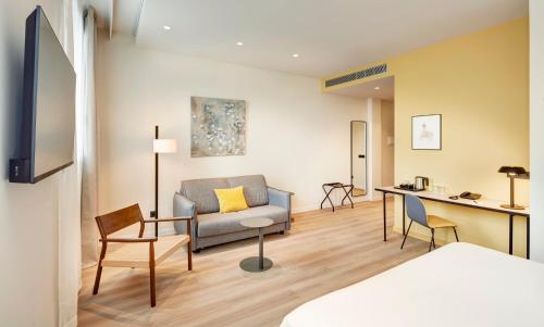 a living room with a couch and a table at Sercotel Barcelona El Prat in El Prat de Llobregat
