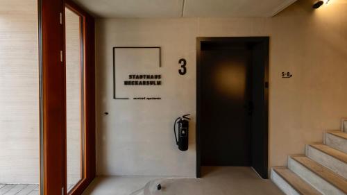 a hallway of a building with a door and stairs at Stadthaus Neckarsulm serviced apartments – Stadthaus Heiner in Neckarsulm