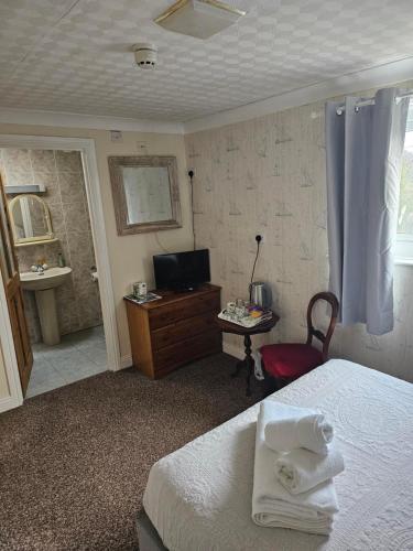 a bedroom with a bed and a bathroom with a television at Castle By The Sea Scarborough in Scarborough