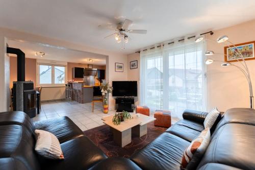 a living room with a leather couch and a table at Charly's House - Parking et terrasse in Houssen