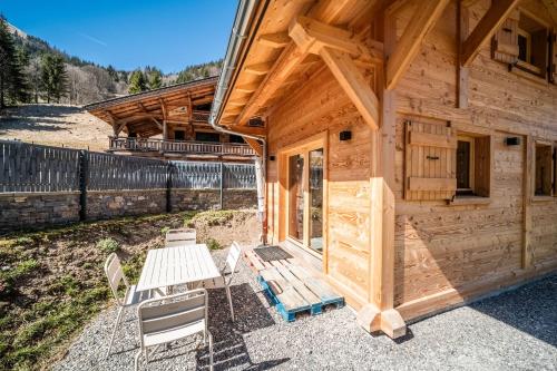 a cabin with a picnic table and chairs outside at Chalet Léonie in Abondance