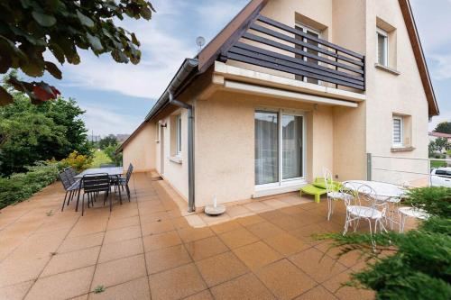 a patio with a table and chairs and a house at Charly's House - Parking et terrasse in Houssen