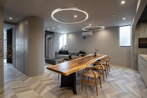 a dining room with a large wooden table and chairs at yado taniguchi in Matsuzaka