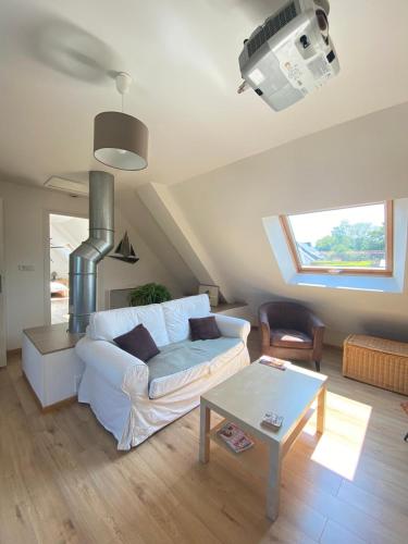 un salon avec un canapé blanc et une table dans l'établissement La Maison aux Paupières Bleues, à Ruca