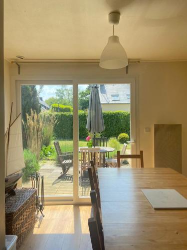 d'une salle à manger avec une table et une porte coulissante en verre. dans l'établissement La Maison aux Paupières Bleues, à Ruca