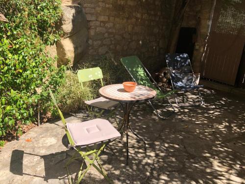 3 chaises et une table avec un bol sur le dessus dans l'établissement studio au coeur de Lacoste, à Lacoste